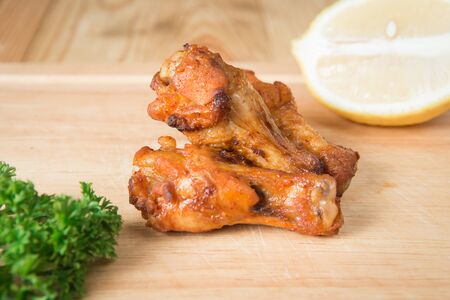 Grilled chicken wing on a wooden block.(Selective focus)の写真素材