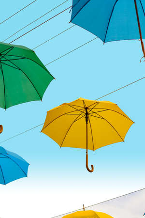 Multi colored umbrellas in blue skyの写真素材