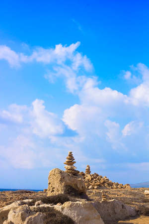 Stones laid out in shape of pyramid on background of Mediterranean sea. Stones laid out tower. Tombs of Kings, an ancient necropolis in Paphos, Cyprusの写真素材