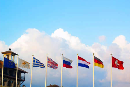Flags of different countries flapping in wind against blue skyのeditorial素材