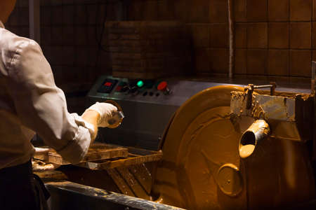 Machine processes and creation of chocolate in dark room. Pouring chocolate. Machine control buttonsの写真素材