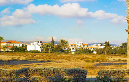 Landscape of town Paphos with houses, trees and mountains in background against blue sky, Cyprus. Photos warm colors of setting sunの写真素材