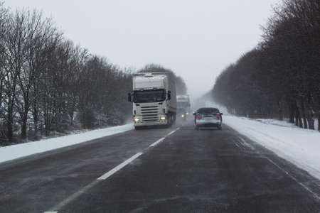 Snowstorm on track with cars ridingの写真素材