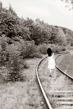 Girl walking on railway near forest. Walks to wonderland, black and white photoの写真素材