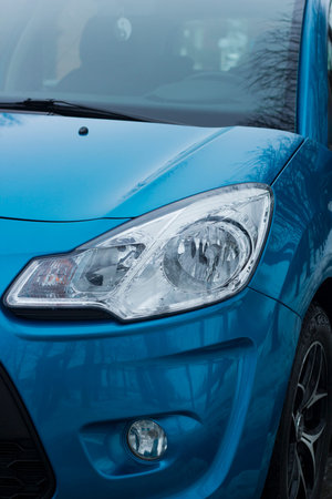 Car headlight on passenger blue car