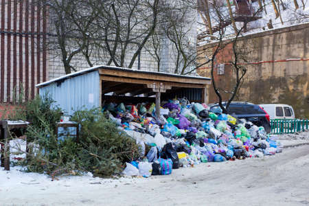 Lvov, Ukraine - January 28, 2017:  Metal hangar and garbage cans covered of large heap garbage on city streetのeditorial素材