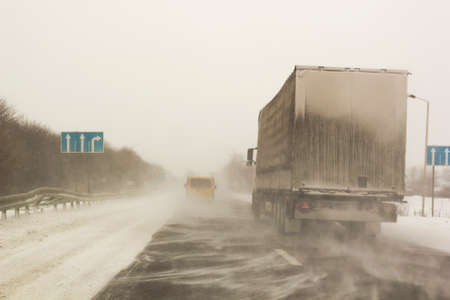 Snowstorm on track with cars ridingの写真素材
