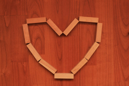 Wooden blocks in shape of Heart on wooden background
