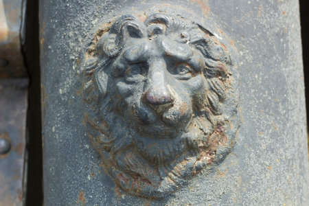 Old metal head of lion sculpture on gun