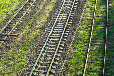 Empty old railroad tracks top view. Railway metal track in green grass