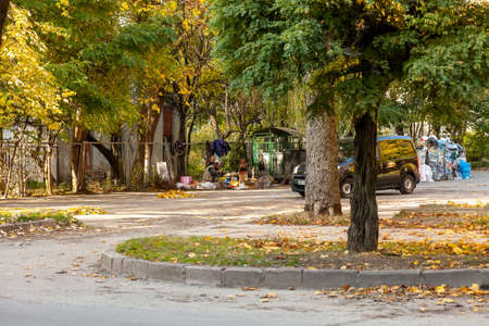 Lviv, Ukraine - 14 October 2019: City street with trees, trash bins and homeless people on picnicのeditorial素材