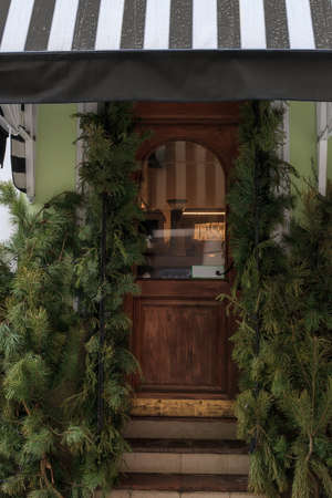 Wooden door with canopy and decorated fir branches. Christmas holidays festive houseの写真素材
