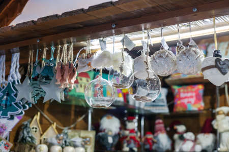 Small various handmade toys selling at Xmas Fair. Christmas market with traditional decorations close up. Holidays kiosk with festive gifts and souvenirs at city streetの写真素材