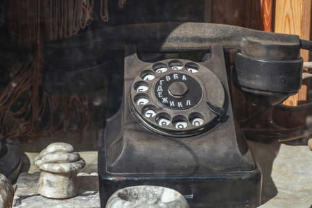 Vintage rusty telephone on table. Retro phone with rotary dial sale on flea market, selective focusの写真素材