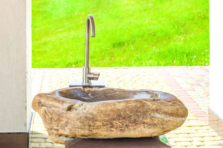 Stone washbasin in the yard. Modern sink in summer backyard at sunny light day, front viewの写真素材