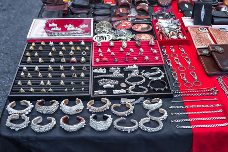 Phuket, Thailand - February 23, 2018: Jewelry made of animals teeth and skin sold on city street. Rings, bracelets, wallets, bangles, belt buckles selling in night market. Various handicraft souvenirのeditorial素材