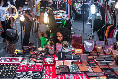 Phuket, Thailand - February 23, 2018: Jewelry made of animals teeth and skin sold on city street. Rings, bracelets, wallets, bangles, belt buckles selling in night market. Various handicraft souvenirのeditorial素材
