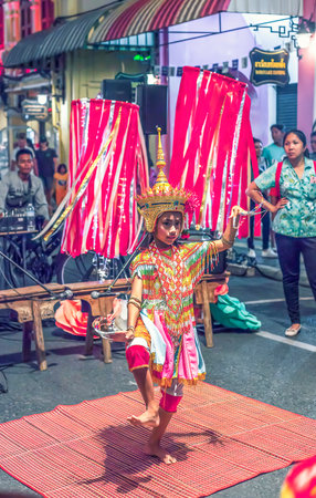 Phuket, Thailand - February 23, 2018: Menora thai traditional dancing on night city street. Tradition Nora dance drama in town. Dance is essentially ritual to worship ancestorsのeditorial素材