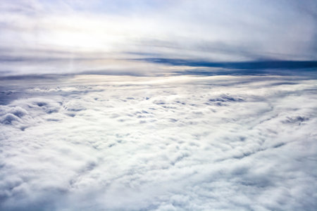Stratiform clouds. Expansive aerial view of fluffy white blanket cloud stretching across sky, bathed in soft light. Themes of freedom, travel, dreams, tranquility. Evokes sense of peace, vastnessの写真素材