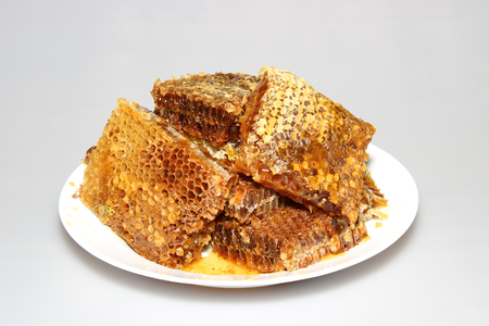 Honey in honeycombs on a plateの写真素材