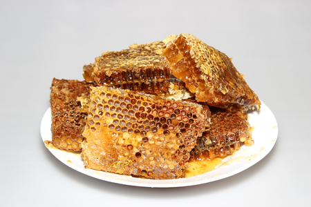 Honey in honeycombs on a plateの写真素材
