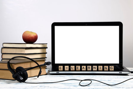 e-learning, laptop, earphone with microphone, apple, stack of books