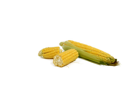 ripe ear of corn and pieces of cob with leaves on a white background, isolate