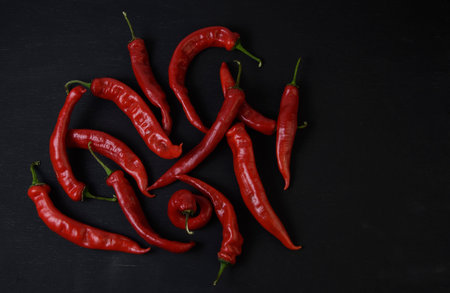 red bitter peppers on a black wooden table