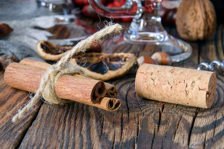 cinnamon sticks tied with twine and a cork from a wine bottle on a wooden table in the background background defocusの写真素材