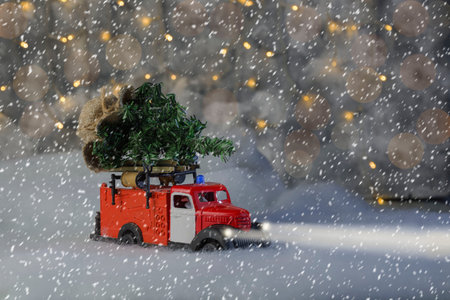 a fire department car is carrying a Christmas tree, it is snowing, a blizzard, headlights are on,...