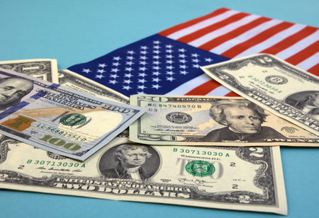 dollar bills and the American flag on a blue background, focus on the foreground