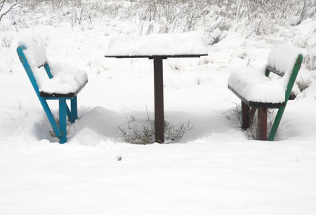 the table and benches are covered with snow