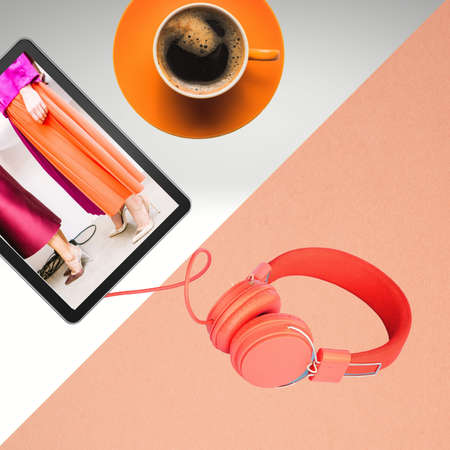 Women's fashion image on a tablet with headset and cup of coffeeの写真素材
