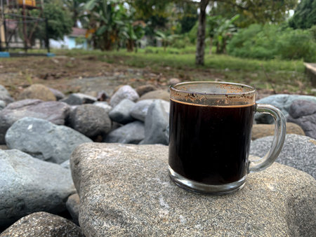 a cup of black coffee on a rock on a rock background