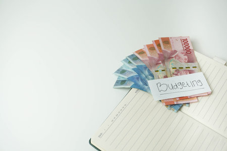 money on a book on a white background. rupiah Indonesian money. budgeting concept. copy spaceの写真素材