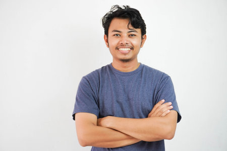 Portrait of smiling or happy handsome asian man in casual t-shirt crossing arms and looking at...
