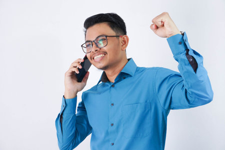 Portrait of excited or happy handsome young asian businessman with glasses in wearing blue shirt...