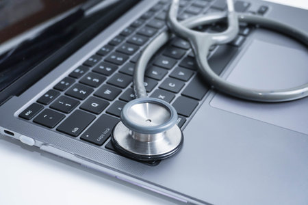 grey Stethoscope on laptop or on the keyboard of pc, close-up. macro view of a grey stethoscope on a...