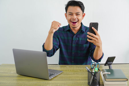 happy young asian man sit work at wooden desk with pc laptop. Achievement business career lifestyle...