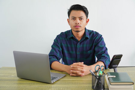 Successful young asian man in blue shirt sit work at wooden desk with pc laptop isolated on white...