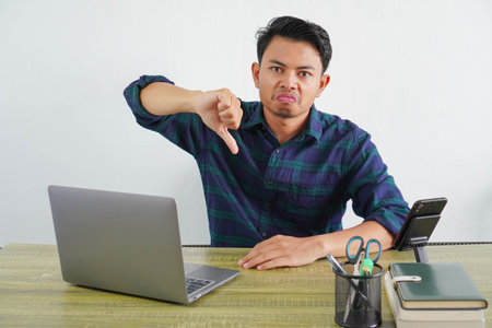Confused young asian man sit work at wooden desk with pc laptop. Achievement business career...