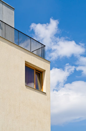 Modern wood house window on yellow wall with blue sky background