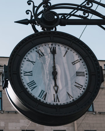 Big vintage old clock hanging on the wall with sky backgroundの写真素材