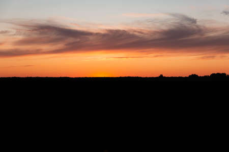 dark sunset silhouette of the earth the horizon and the red sky gradientの写真素材