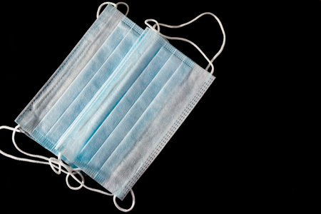 Medical mask, Medical protective mask on black background. Disposable surgical face mask cover the...