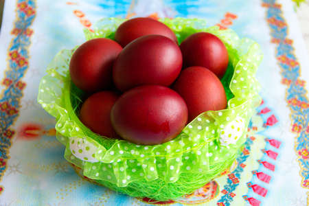 Basket with easter cake and red eggs on rustic wooden table.の写真素材