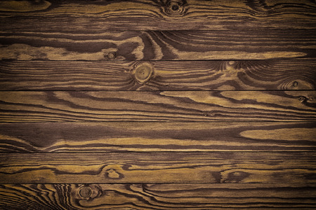 Dark brown scratched wooden cutting board. Wood texture の写真素材