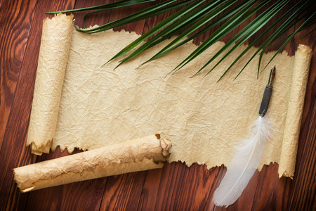 Closeup of scroll and quill near ink-pot on wooden tableの写真素材