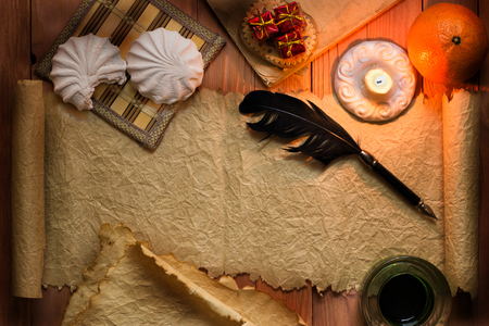 Parchment paper with feather and burning candles vintage style  with wooden backgroundの写真素材