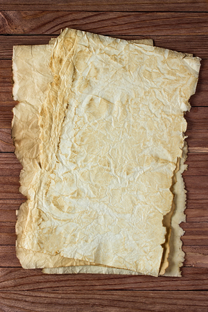 Clean sheet of crumpled paper on a wooden surface backgroundの写真素材